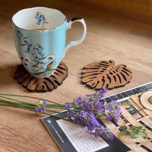 Monstera-shaped upcycled teak wood coasters, available as a set of 2 or 4.